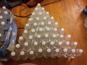 Aerin Johnson organizes her water bottles as she labels them.  